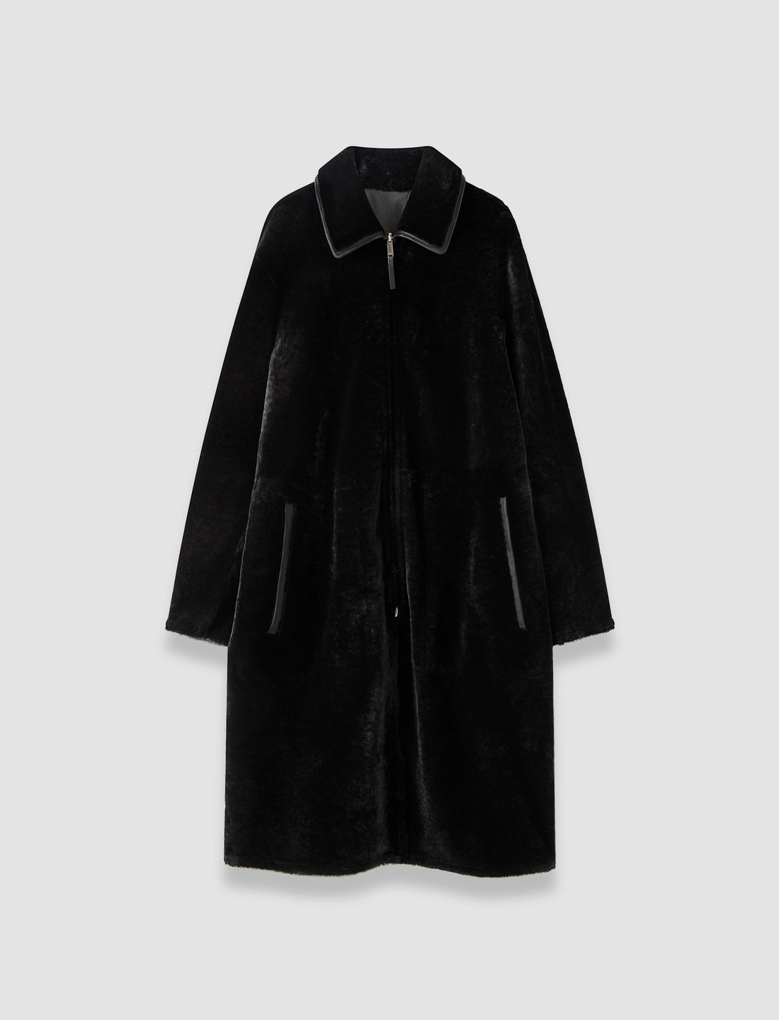 Long black shearling coat showing the fleece side, with a collar and front zipper